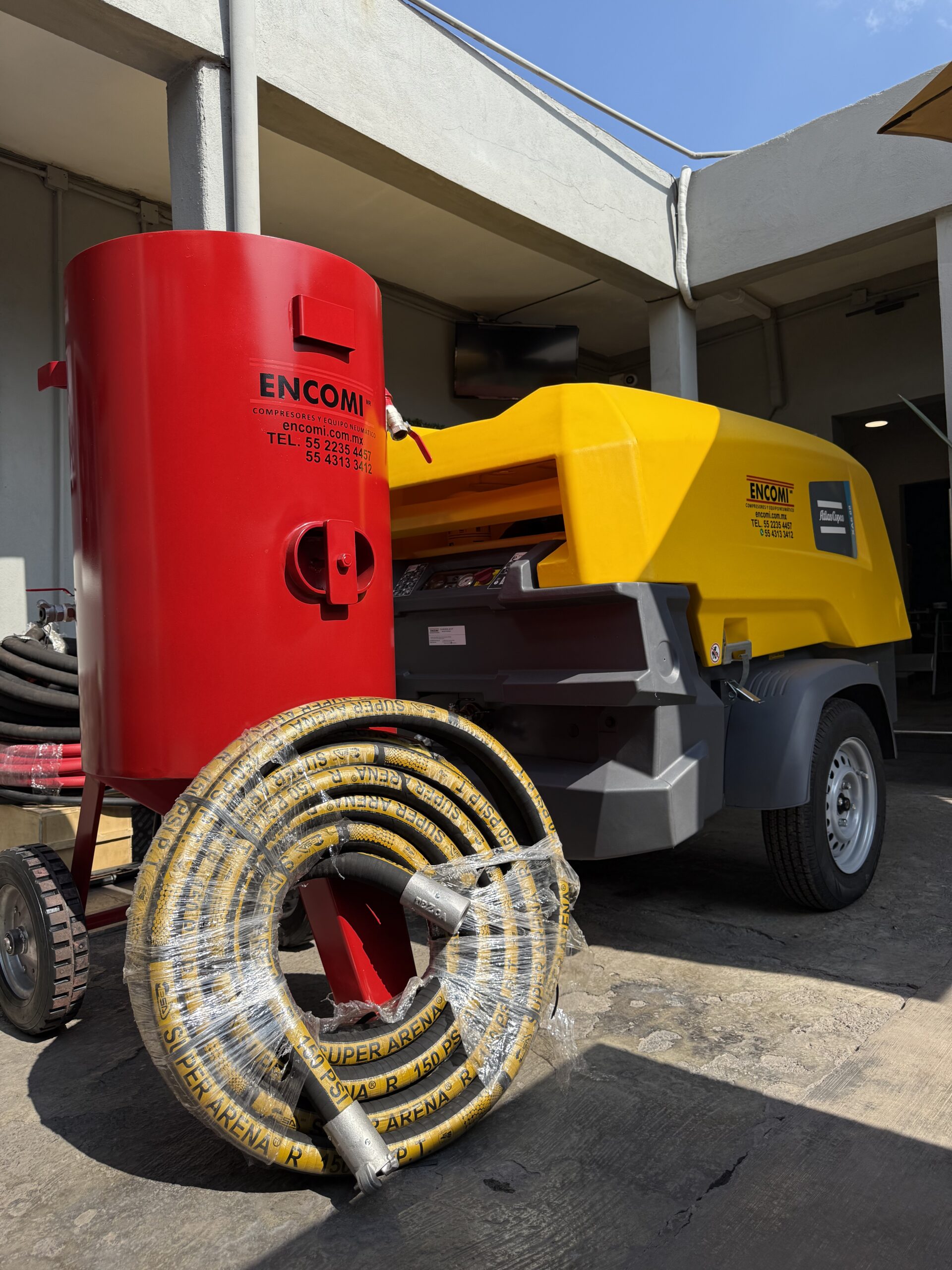 Olla de snadblast ENCOMI de 272kg junto a compresor 185 cfm y manguera enrollada